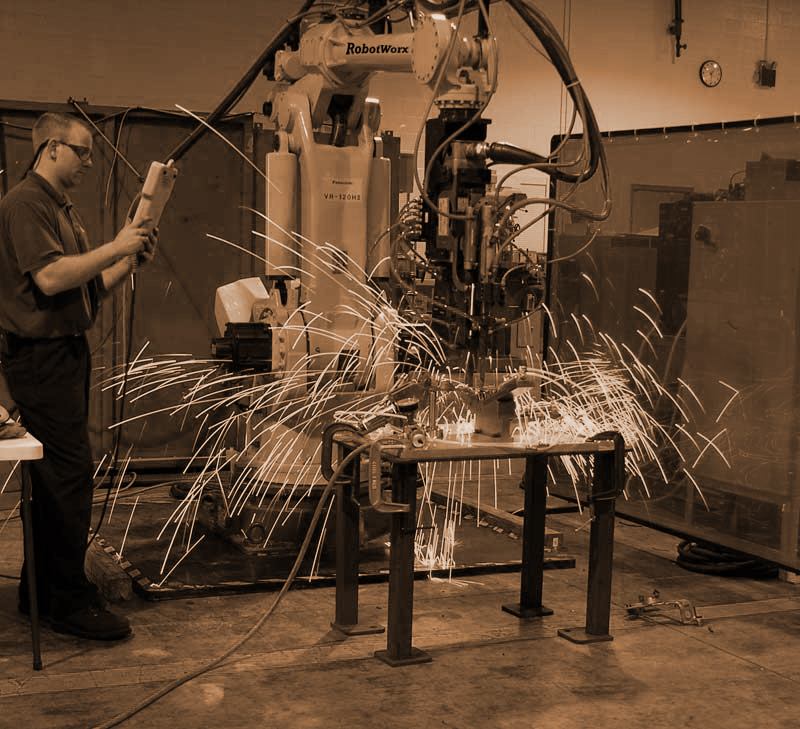 man operating a spot-welding robot